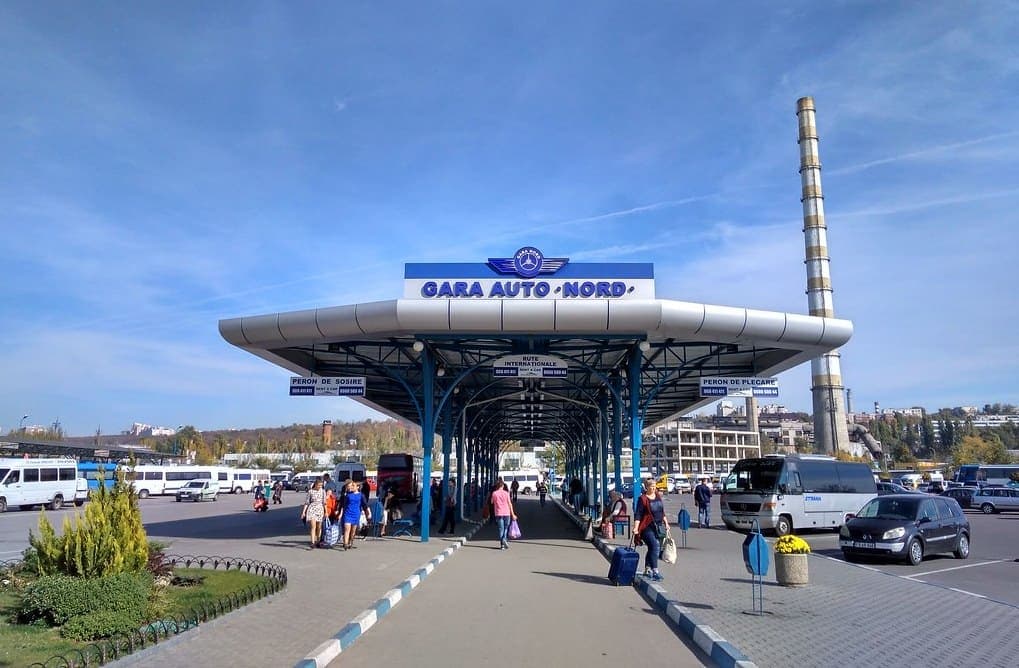 Peronul Gării Auto Nord din Chișinău, sub copertina albă, cu microbuzele și autocarele de o parte și de alta